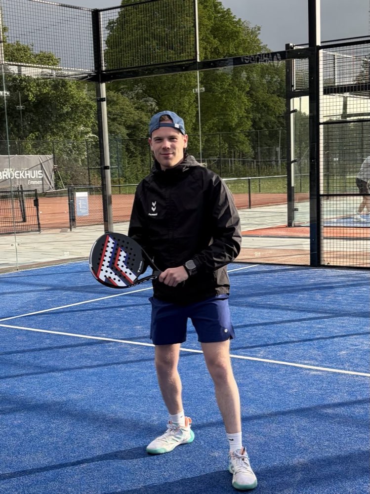 Speler met racket op de blauwe padelbaan